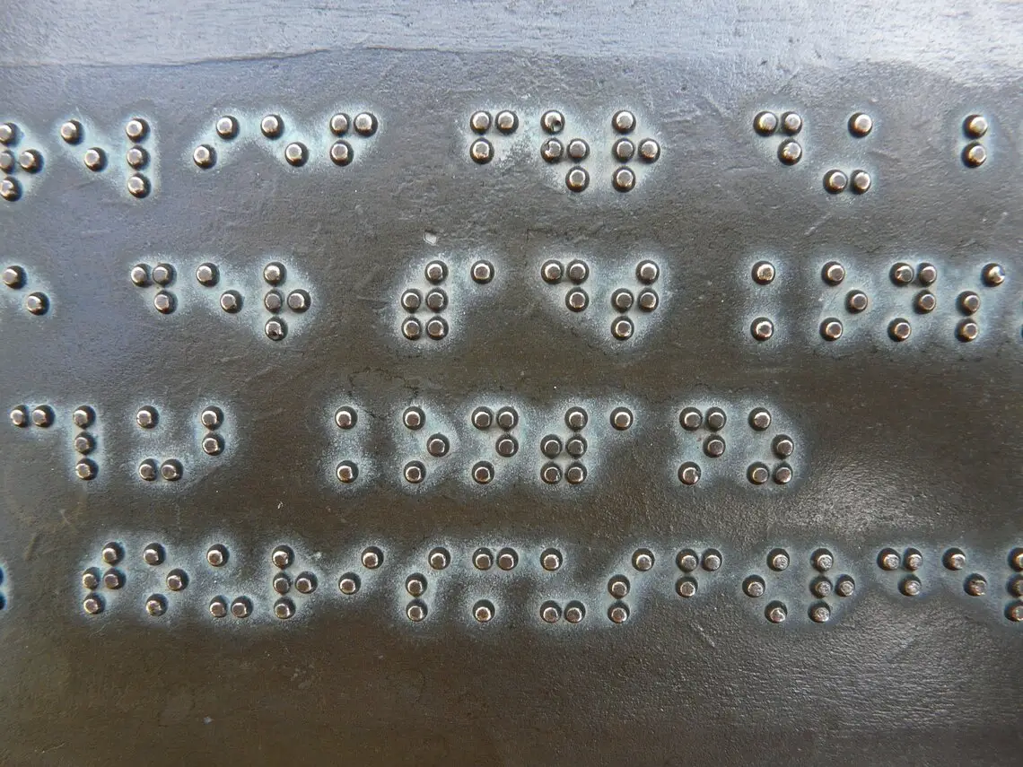 Ecritures en braille sur du métal.