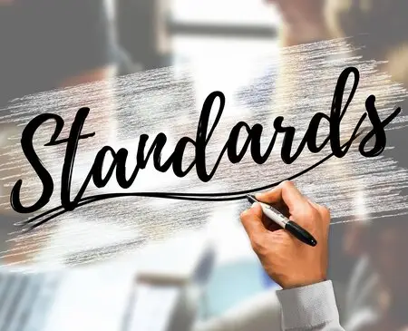 Le mot "standards" est écrit par une main sur un fond décoratif.